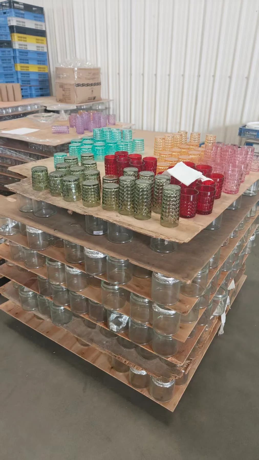 Textured tumblers in a range of colors, grouped on trays above clear glassware.