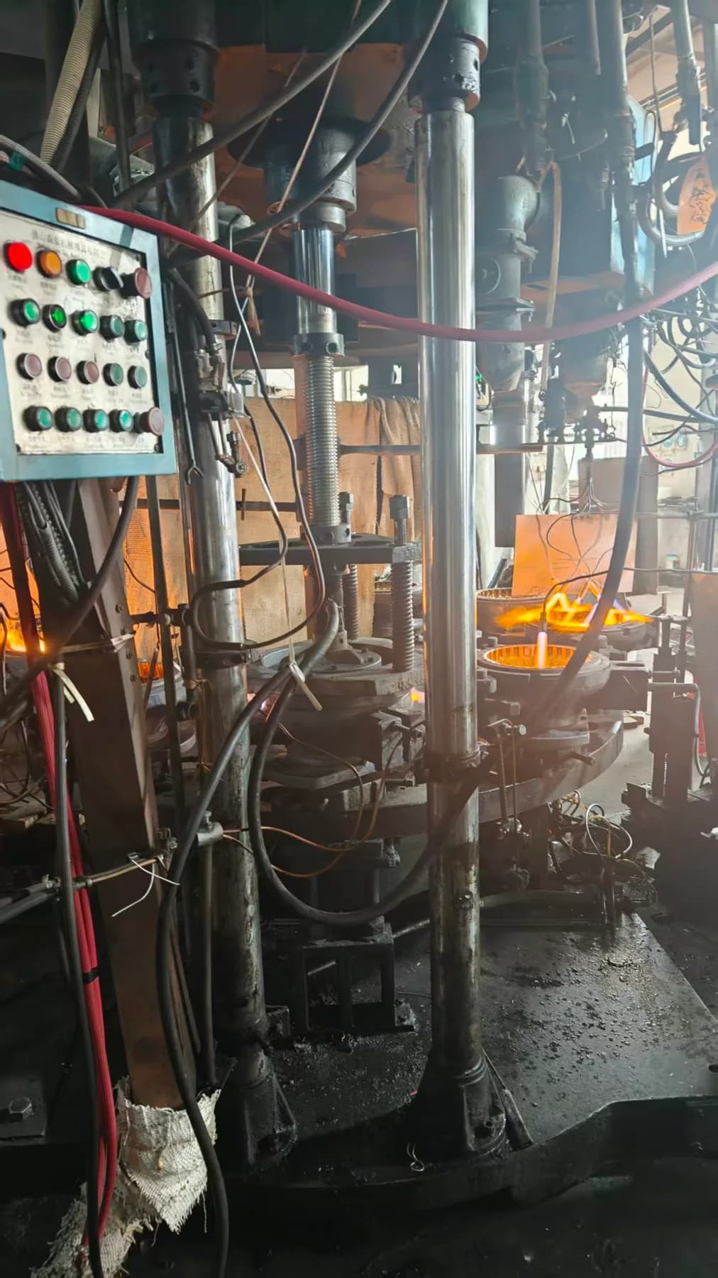 A close view of the forming machinery, with heated molds and press components.