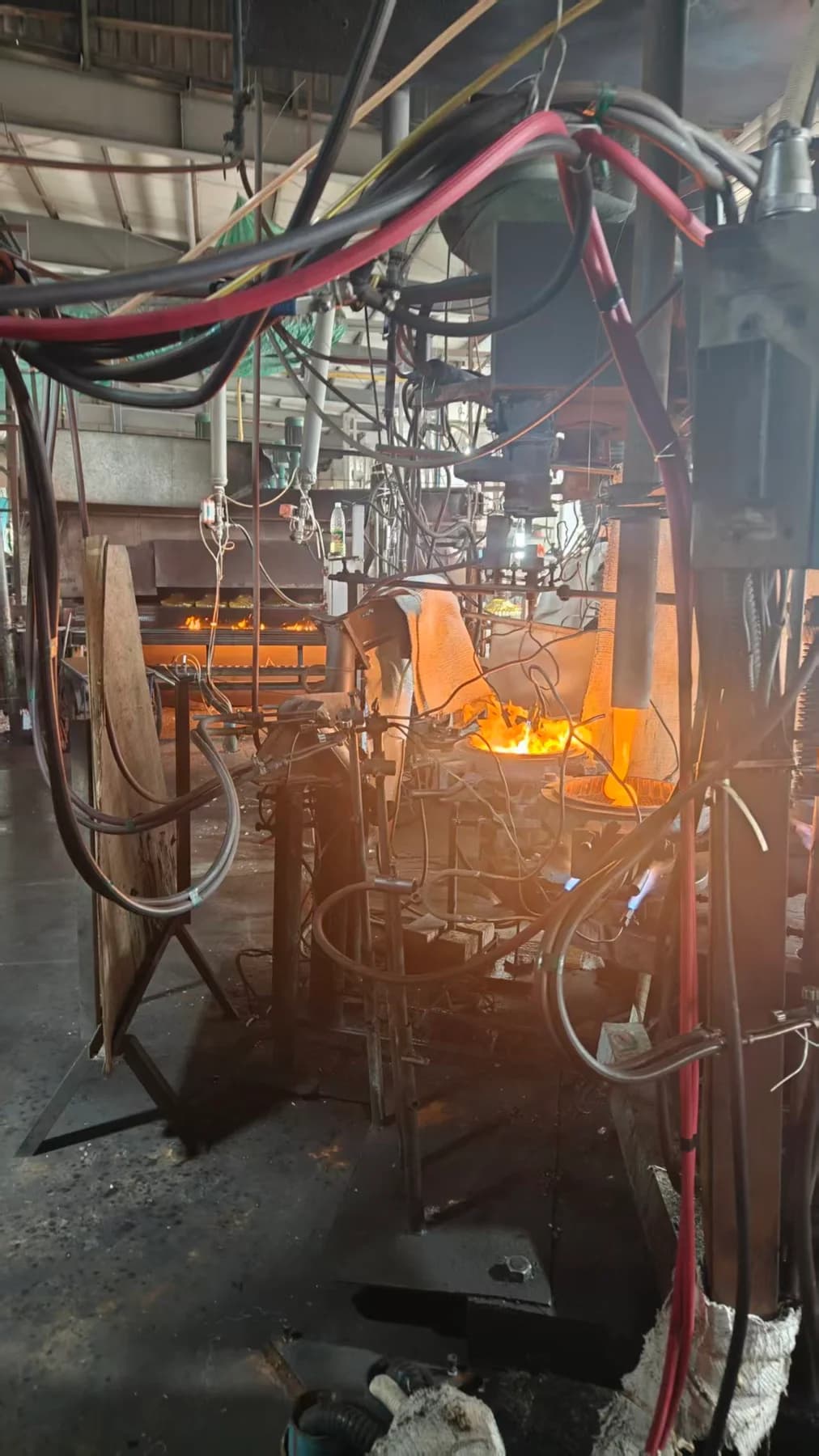 Heated glass and forming stations on the workshop floor.