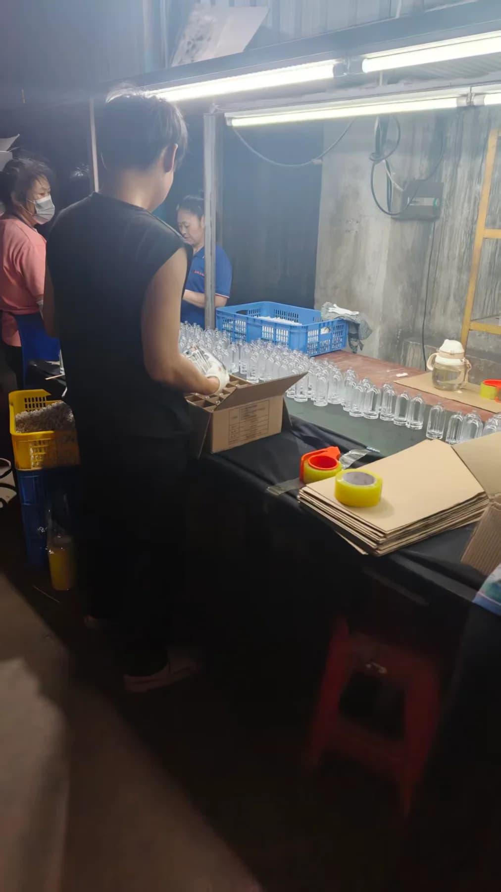 Glass pieces being placed into individual cardboard compartments for packing.