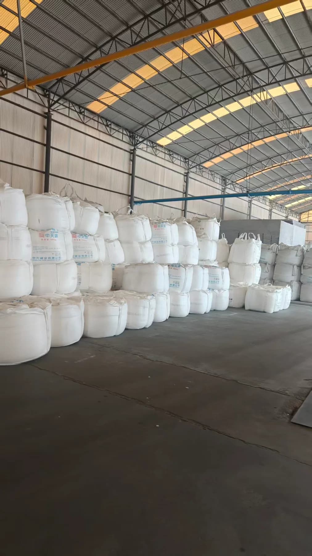 Bulk bags of production materials stored inside the factory warehouse.